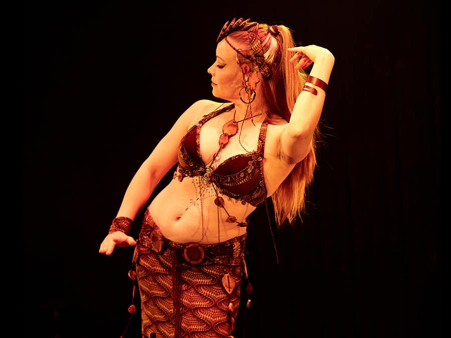 Drucilla dancing in a red belly dance costume