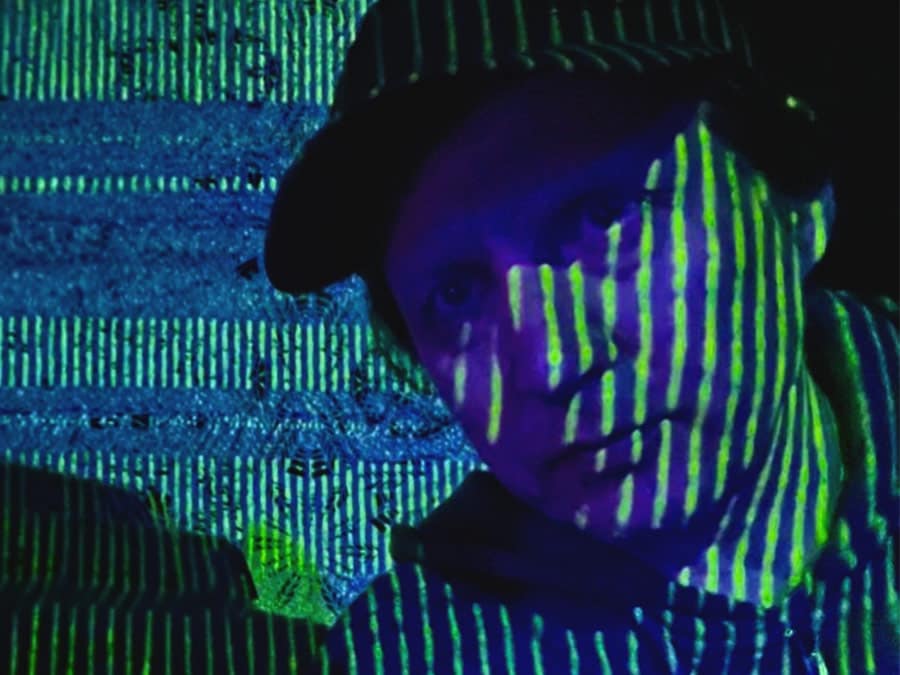 Snyper with green striped light projected across his face