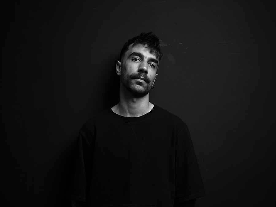 Black-and-white portrait of Nulla Taar against a dark background