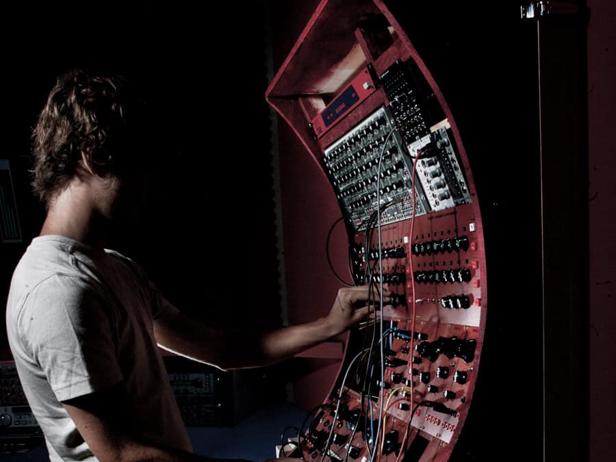 Electrypnose patching a large modular synthesizer in a dim studio