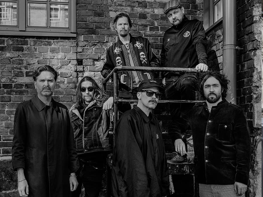 Black-and-white photo of the five members of Hidria Spacefolk on an outdoor staircase