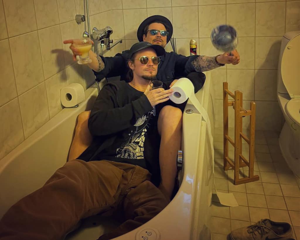 Kryptine and Mocci lounging in a bathtub with toilet rolls and a disco ball