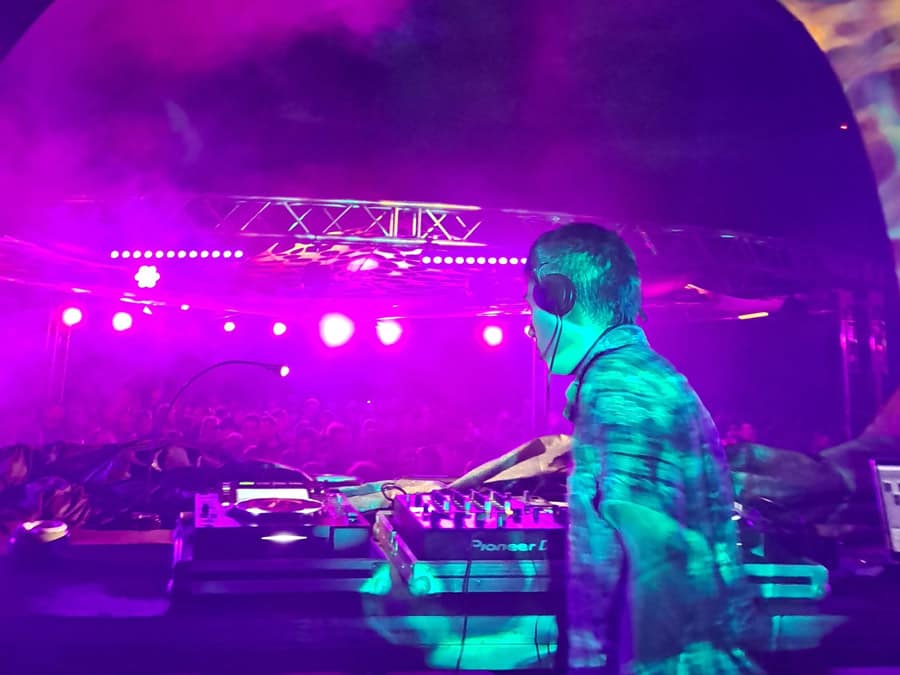 Eeriegeist at the decks on a stage bathed in purple light