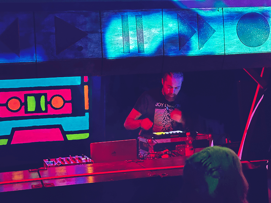 KIWA playing live under neon cassette-tape visuals