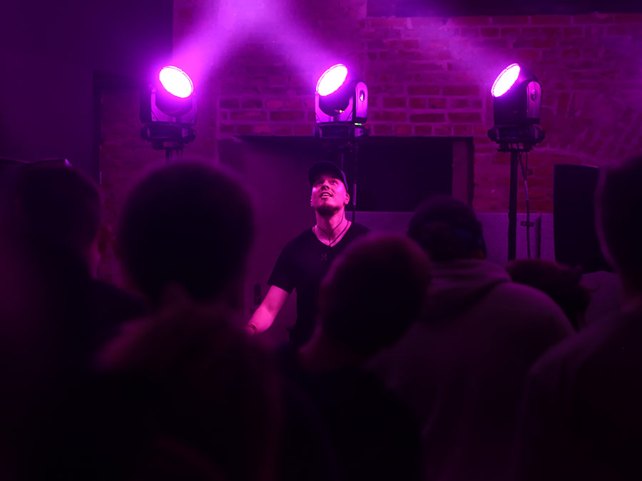 Vanhis on stage under purple spotlights above the crowd