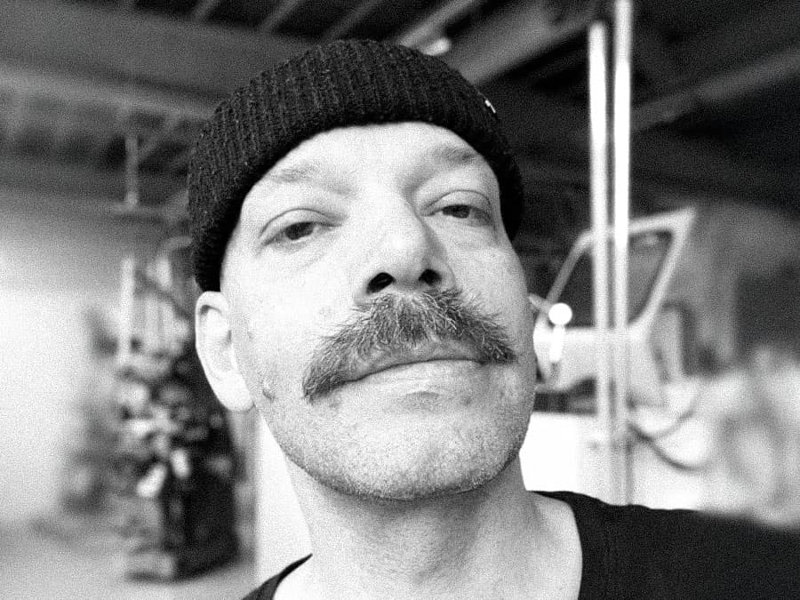 Black-and-white close-up of Tymon in a beanie with a moustache