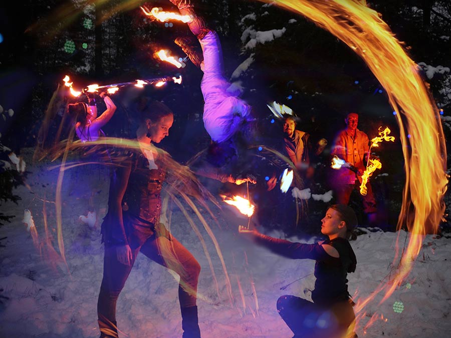 Löyly performers with fire hoops and fire staffs in the dark