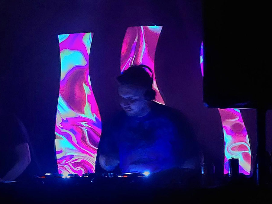 Ultra DJing in front of psychedelic video screens