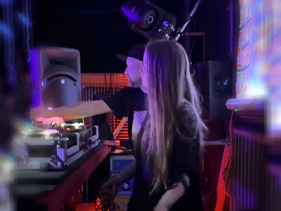 Gaida at the decks, blurred with motion under stage lights