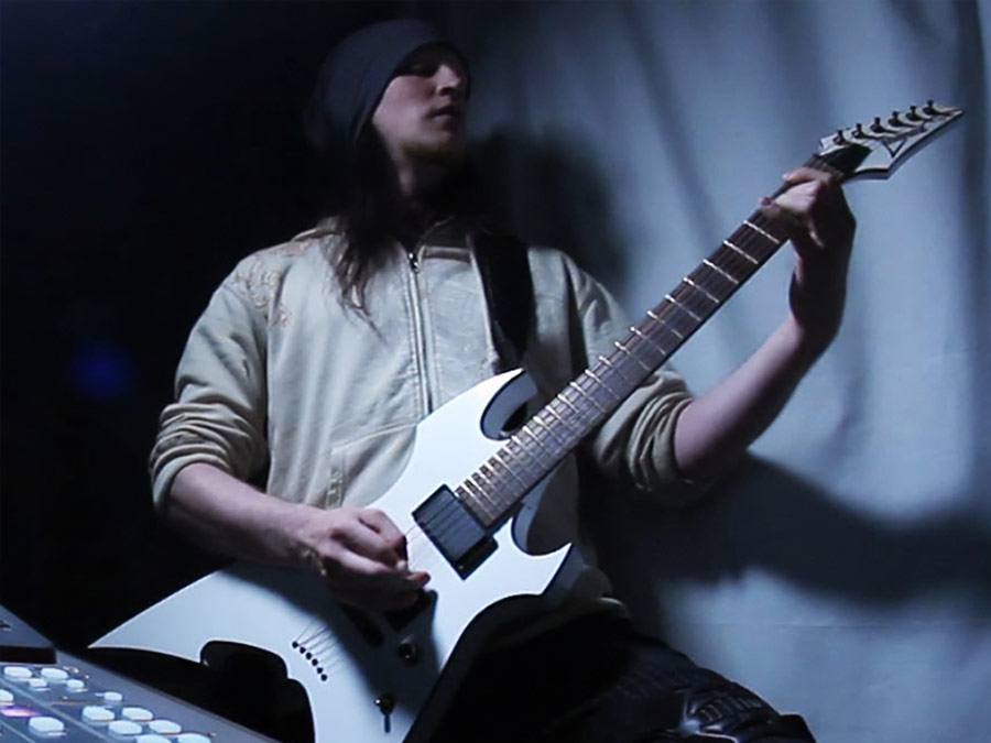 Byproduct playing a white electric guitar against a dark backdrop