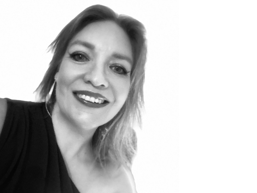 Smiling portrait of Annie West against a white background