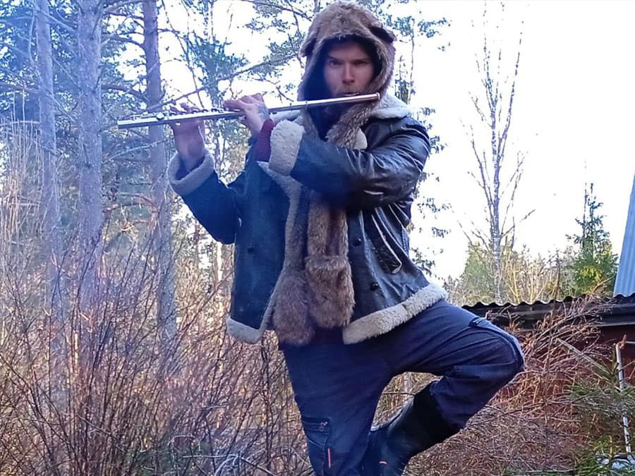 Hämeen Nopein in a fur hood, playing a flute in a forest