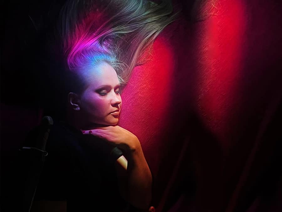 Lahtine with pastel-coloured hair in red light