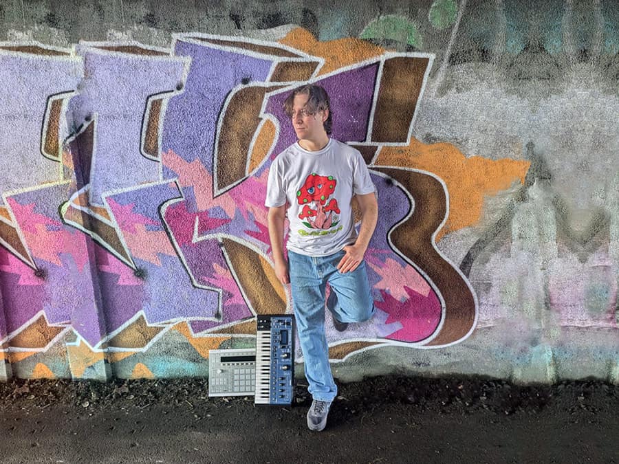 Transcend with a keyboard in front of a HUG graffiti wall