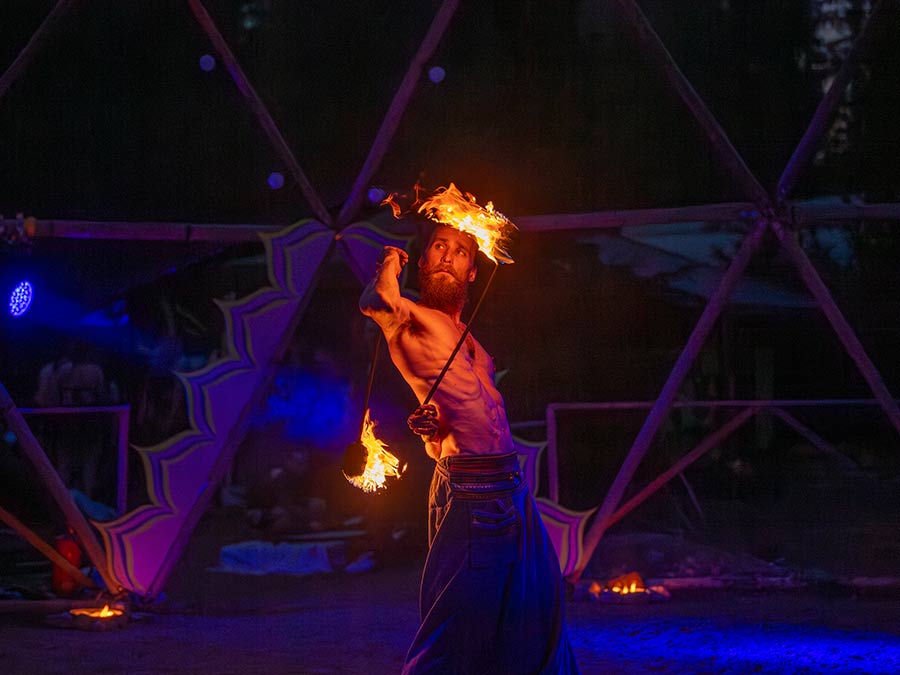 Special Movement Man spinning fire under a geodesic dome in blue light
