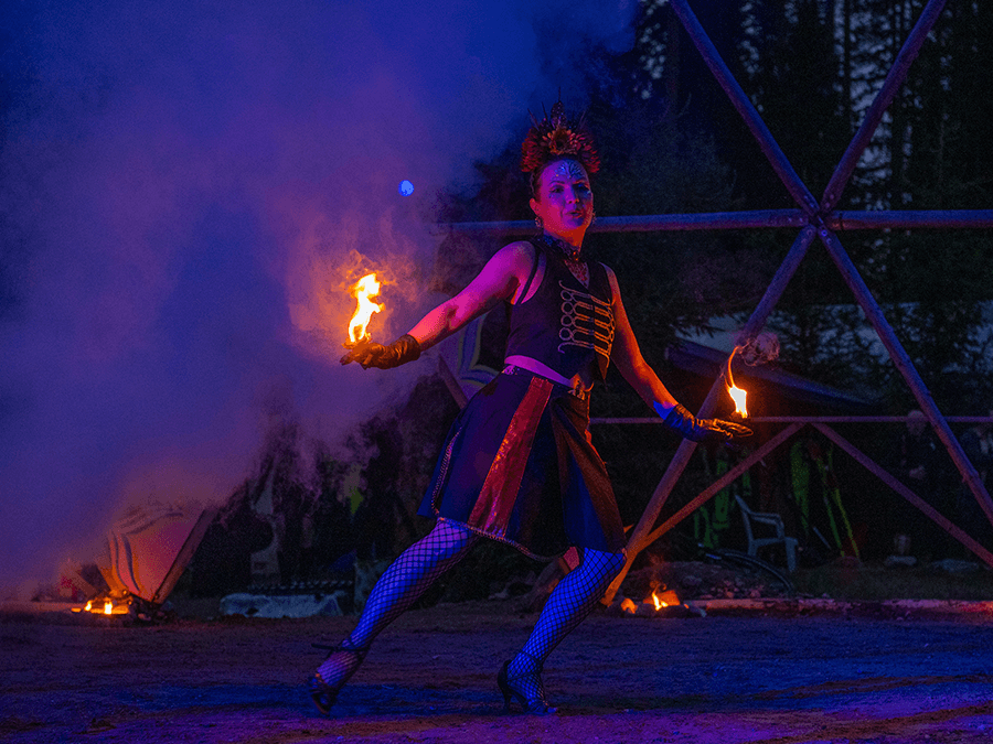 Mimi Von Starling in a corset twirling fire props in smoke