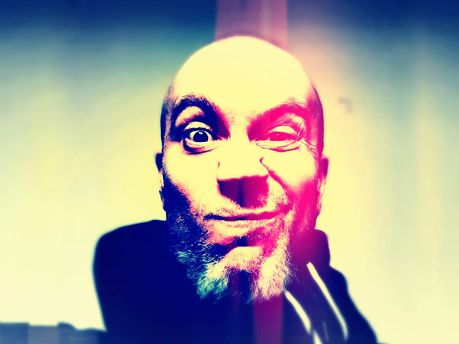 A colour-saturated close-up of SiENiS pulling a wide-eyed face