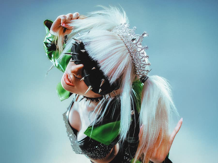 Nenerchy with white pigtails, a spiked mask and green sunglasses