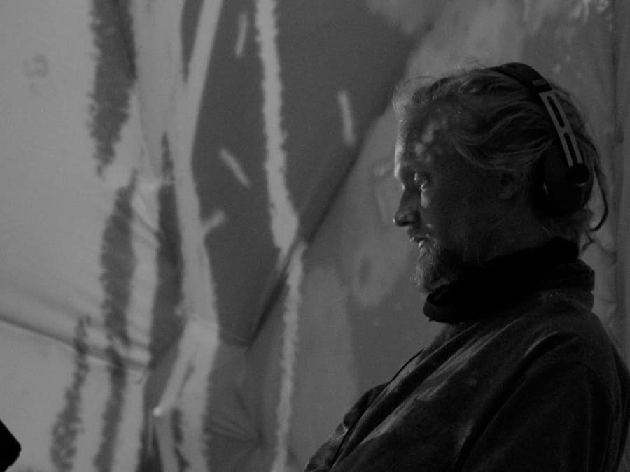 Black-and-white photo of Mosaiq wearing headphones